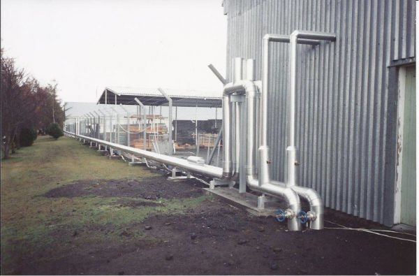 Galvanised pipework run along a building